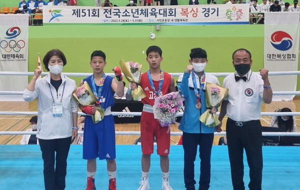 복싱종목에서 금메달을 획득한 문치윤학생이 김정애 교육장 및 은, 동메달을 획득한 선수들과 파이팅을 하고 있다.