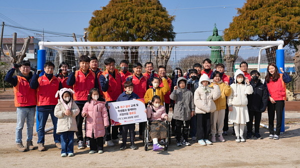  경남 고성군 동해초등학교를 찾은 SK오션플랜트 띠앗봉사단 구성원들이 학생들과 함께 새 축구골대 앞에서 기념촬영을 하고 있다.
